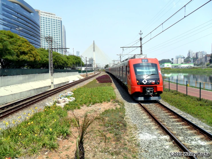 a train that is on a rail line near a large building