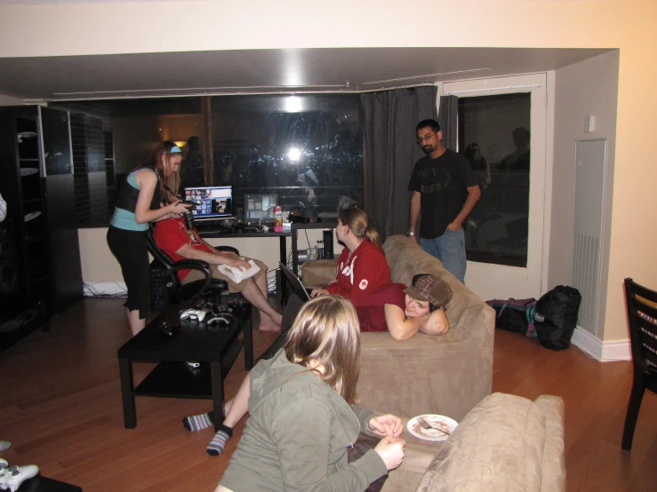 a group of people sitting in chairs around a living room