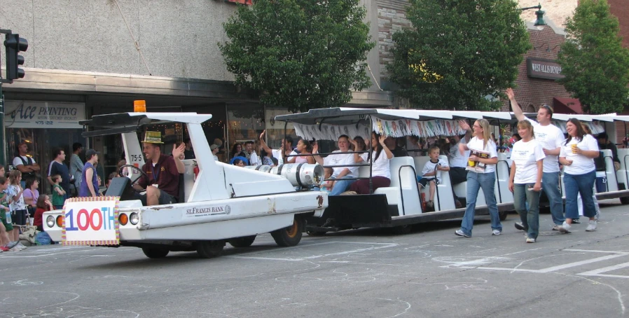 many people are waiting on the side of a small boat in the street