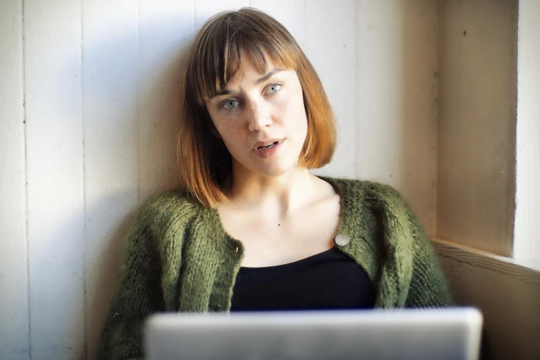 a woman sitting in front of a laptop computer