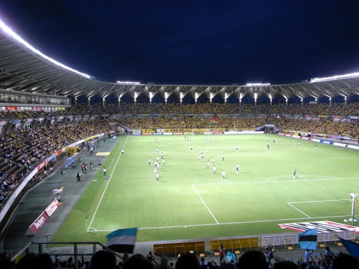 an overview of the soccer field at night with the crowd watching