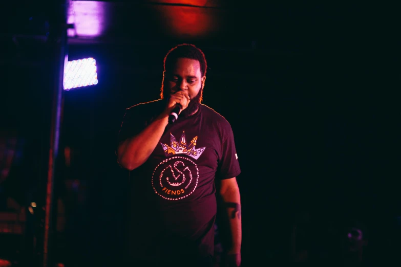 a man holding a microphone stands in front of lights