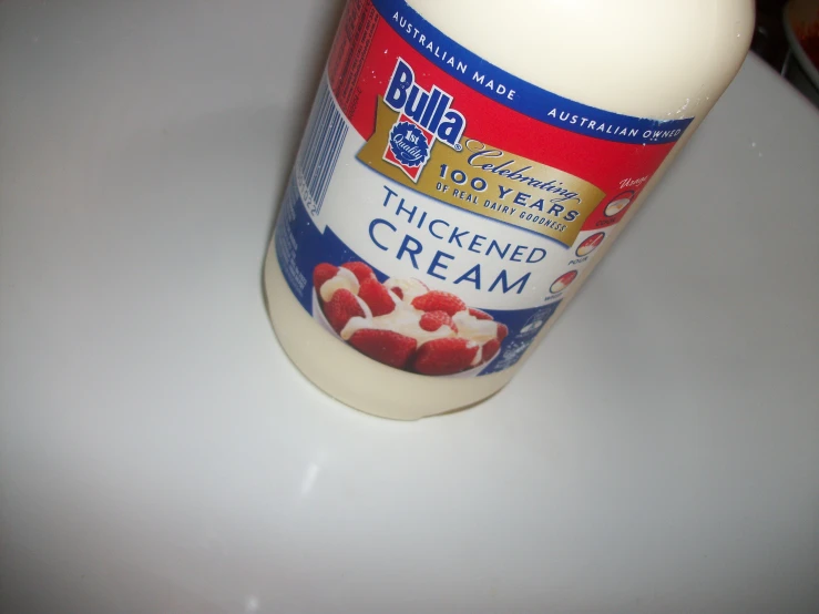 an open bottle of thickened cream is sitting on a white counter