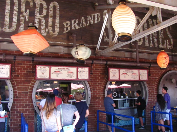 a restaurant with people in it and many lighting fixtures