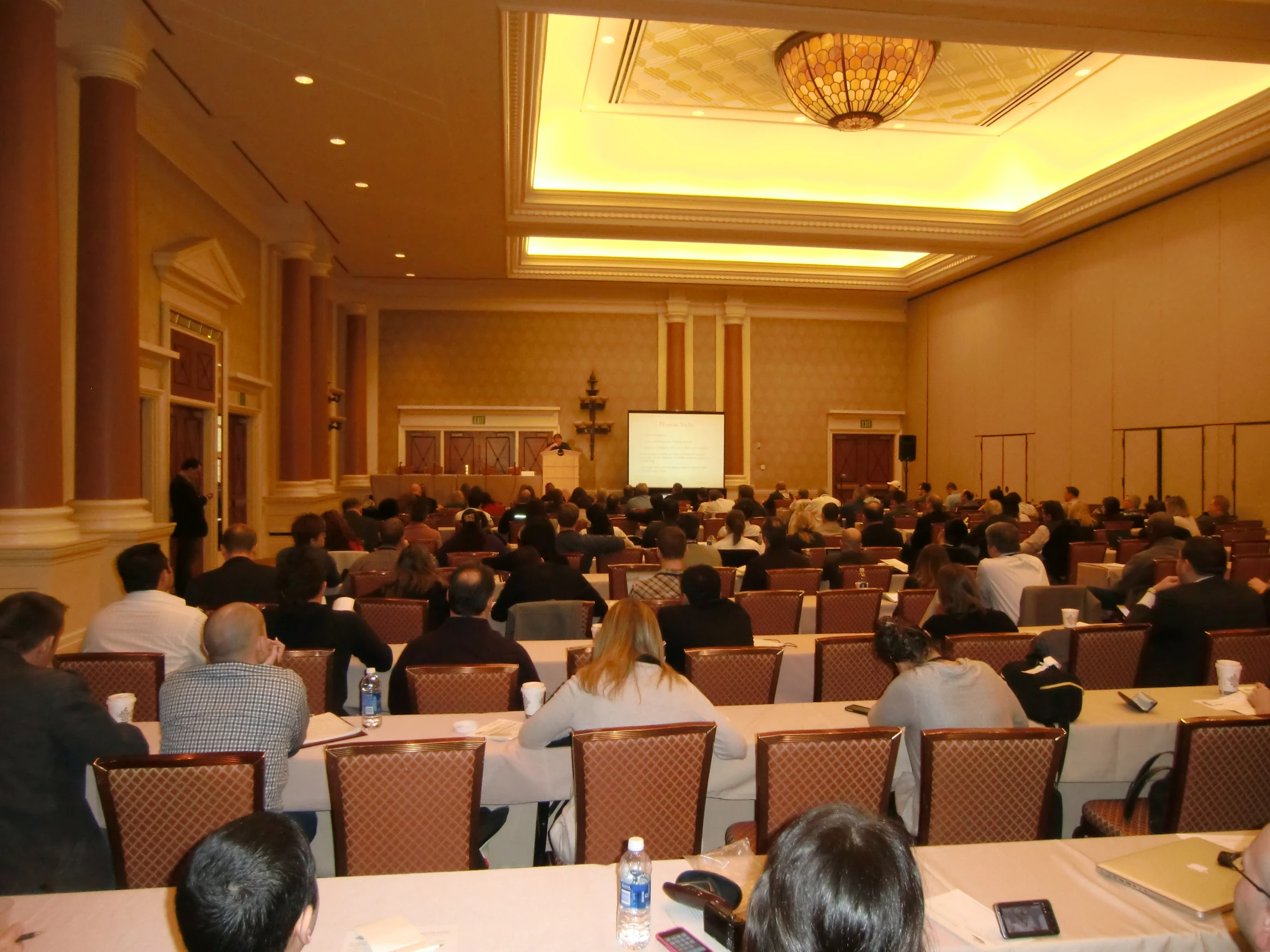 several people sitting in chairs at a lecture hall