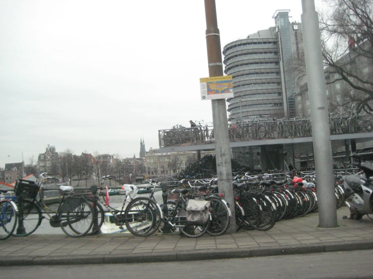 several bicycles parked at a stop sign on a city sidewalk