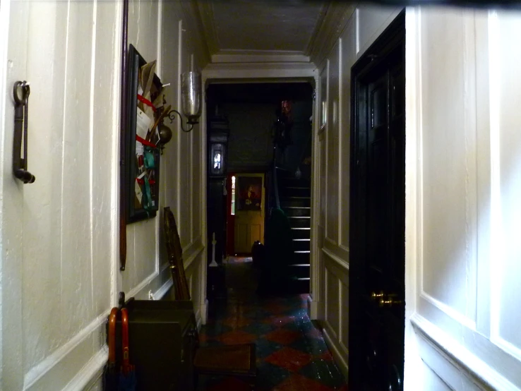 a hallway with a painting on the wall and two suitcases on the floor