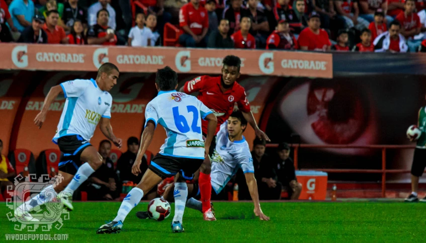 three soccer players in red and white are competing for the ball