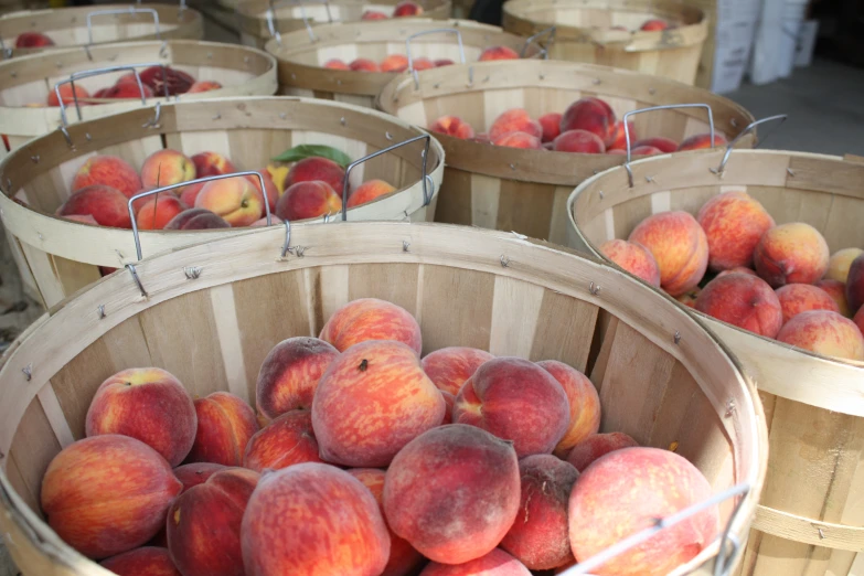 wooden baskets are filled with many peaches