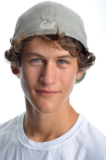 a young man with curly hair wearing a baseball hat