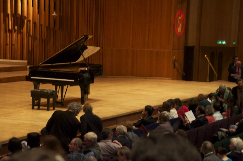 a man playing the piano on stage in front of an audience