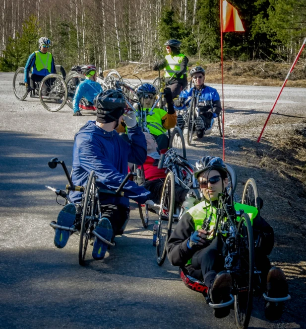 several people sitting on bicycles outside on a paved path