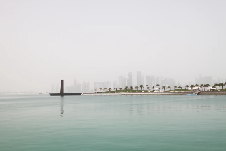 a building sits next to a body of water with palm trees in the background