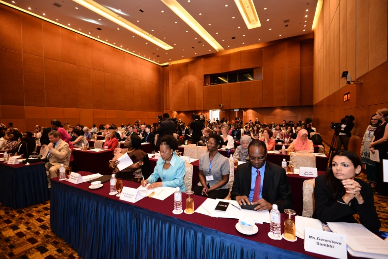 a large room full of people sitting in front of laptops