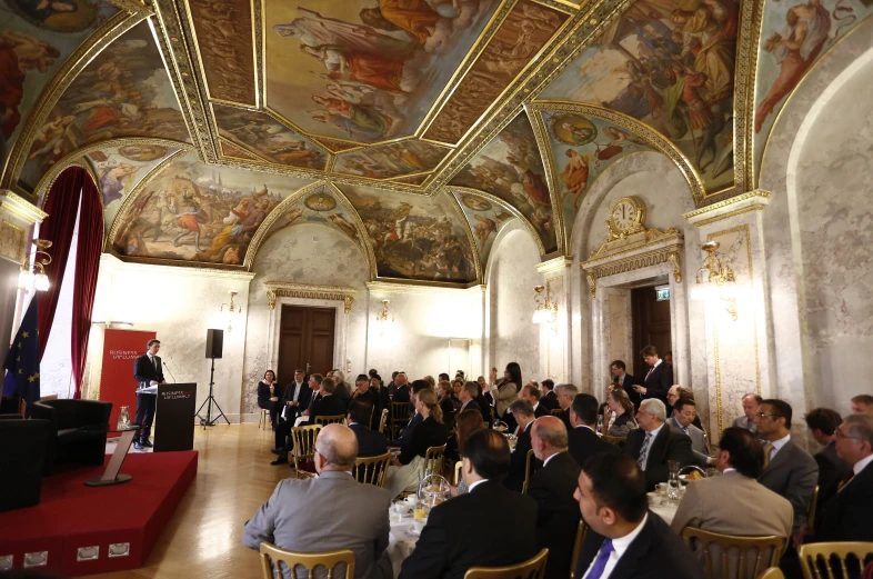 the crowd is enjoying a conference in the state dining room