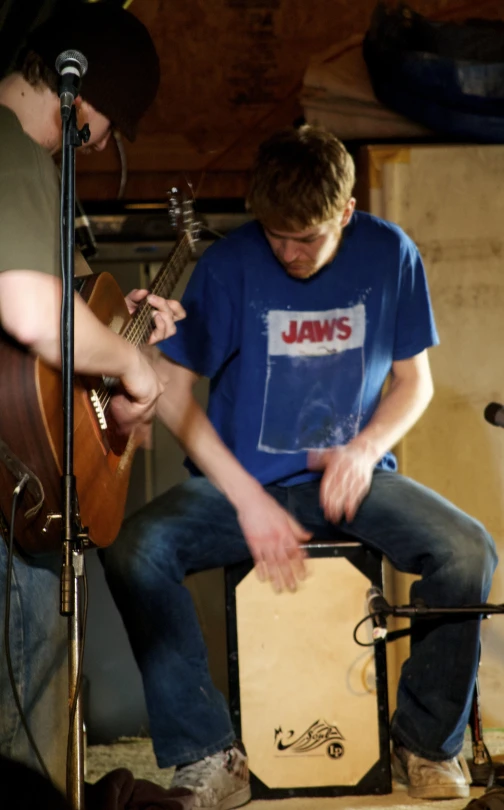 a man plays the guitar next to another person