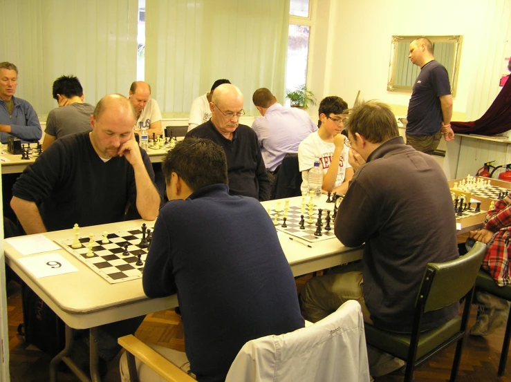 a group of people playing chess at a table