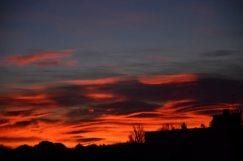 the silhouettes of buildings against the sunset