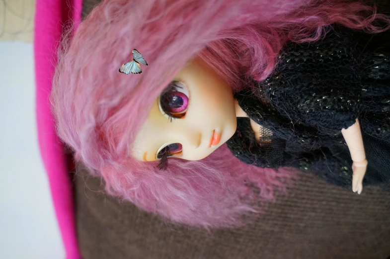 a doll has pink hair and a erfly