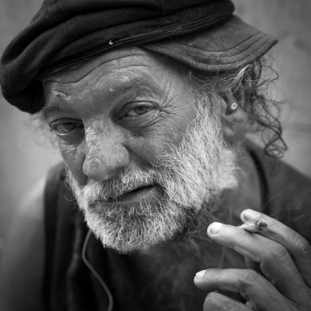 a man with a beard and  has a cigarette in his hand