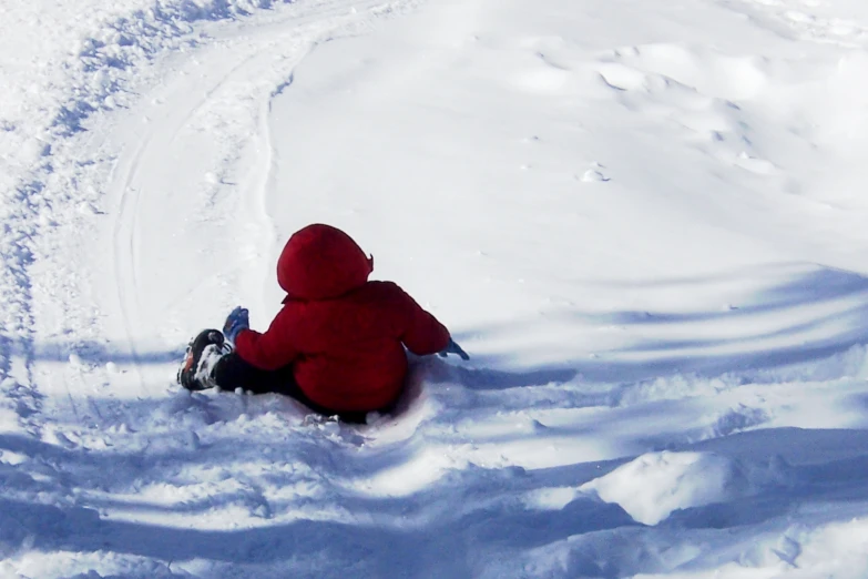 a young child wearing a red coat and black boots in the snow