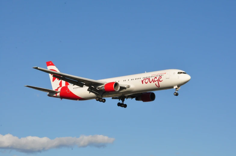 large plane with red and white tail flying in a blue sky