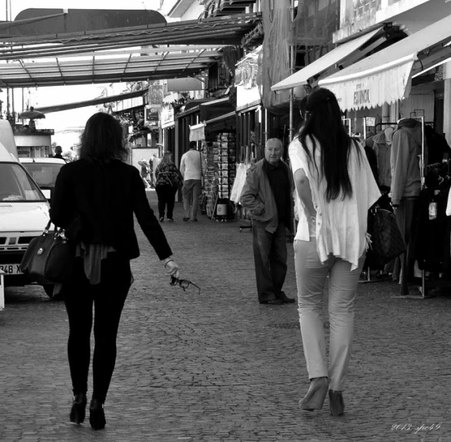 a woman is walking down a small city street