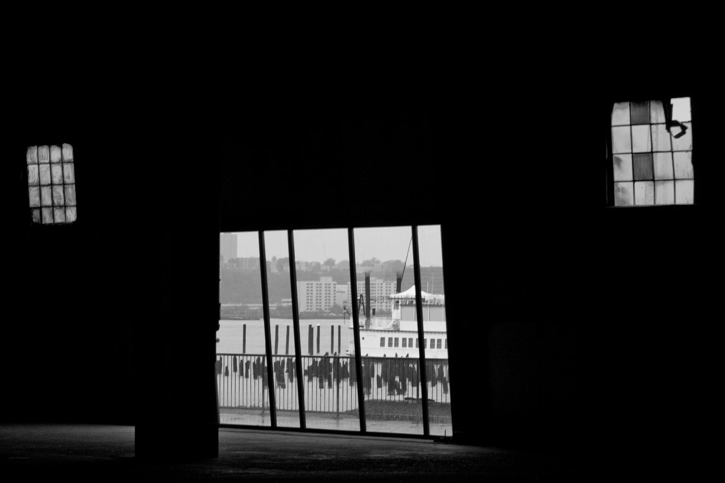 black and white pograph of some windows, with skyline in the background