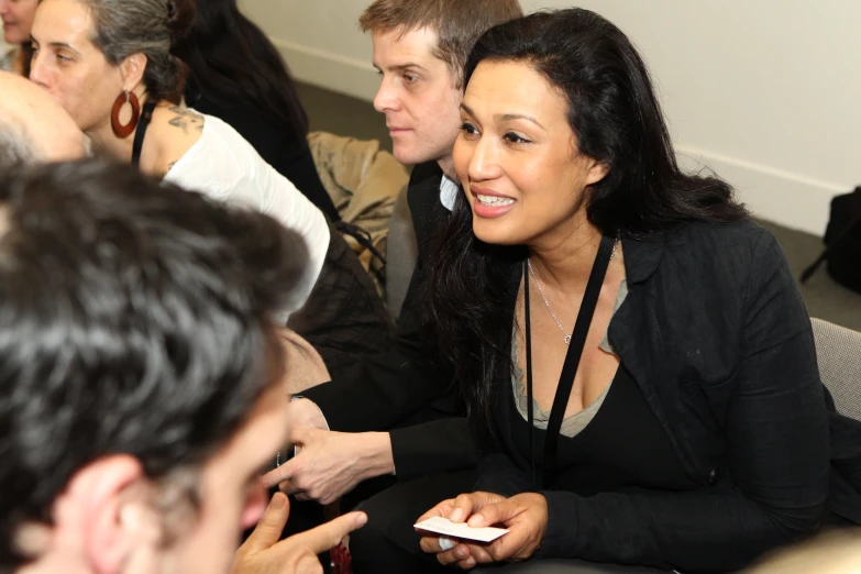 three people sitting side by side and one is holding a remote