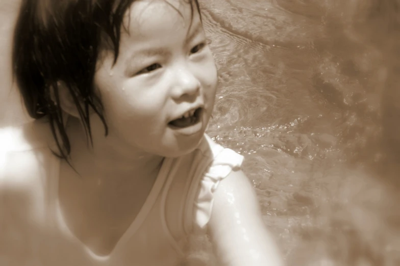 an adorable little girl who is laughing while in a water slide