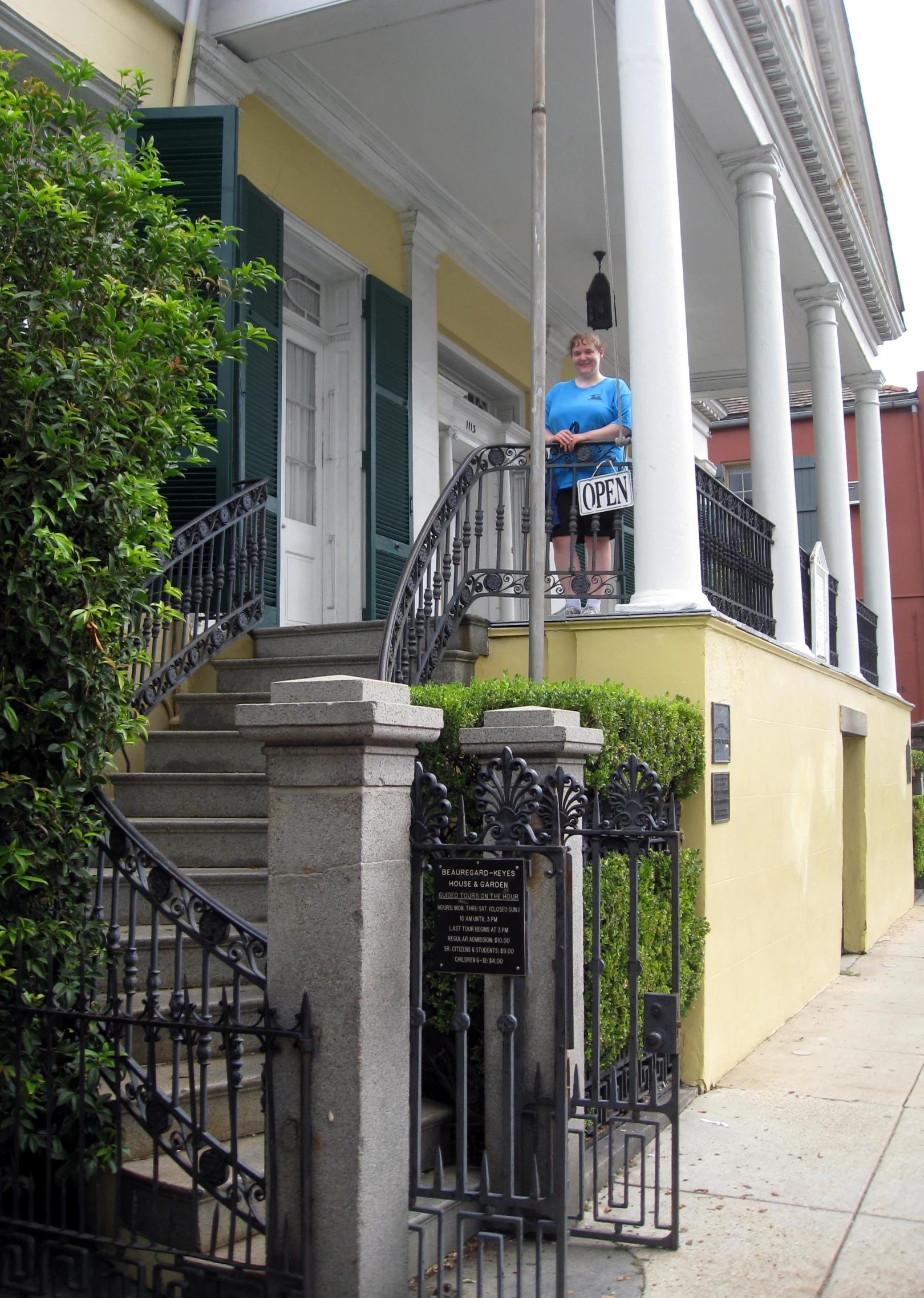 a woman in blue top standing on the front steps