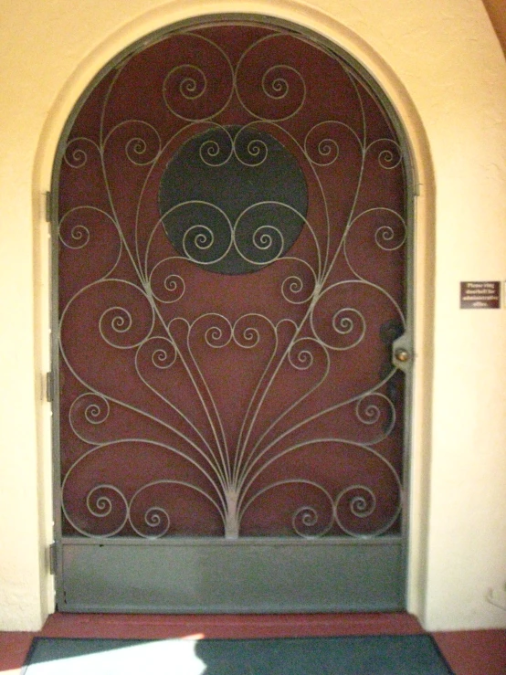 an iron door has a design that looks like a peacock