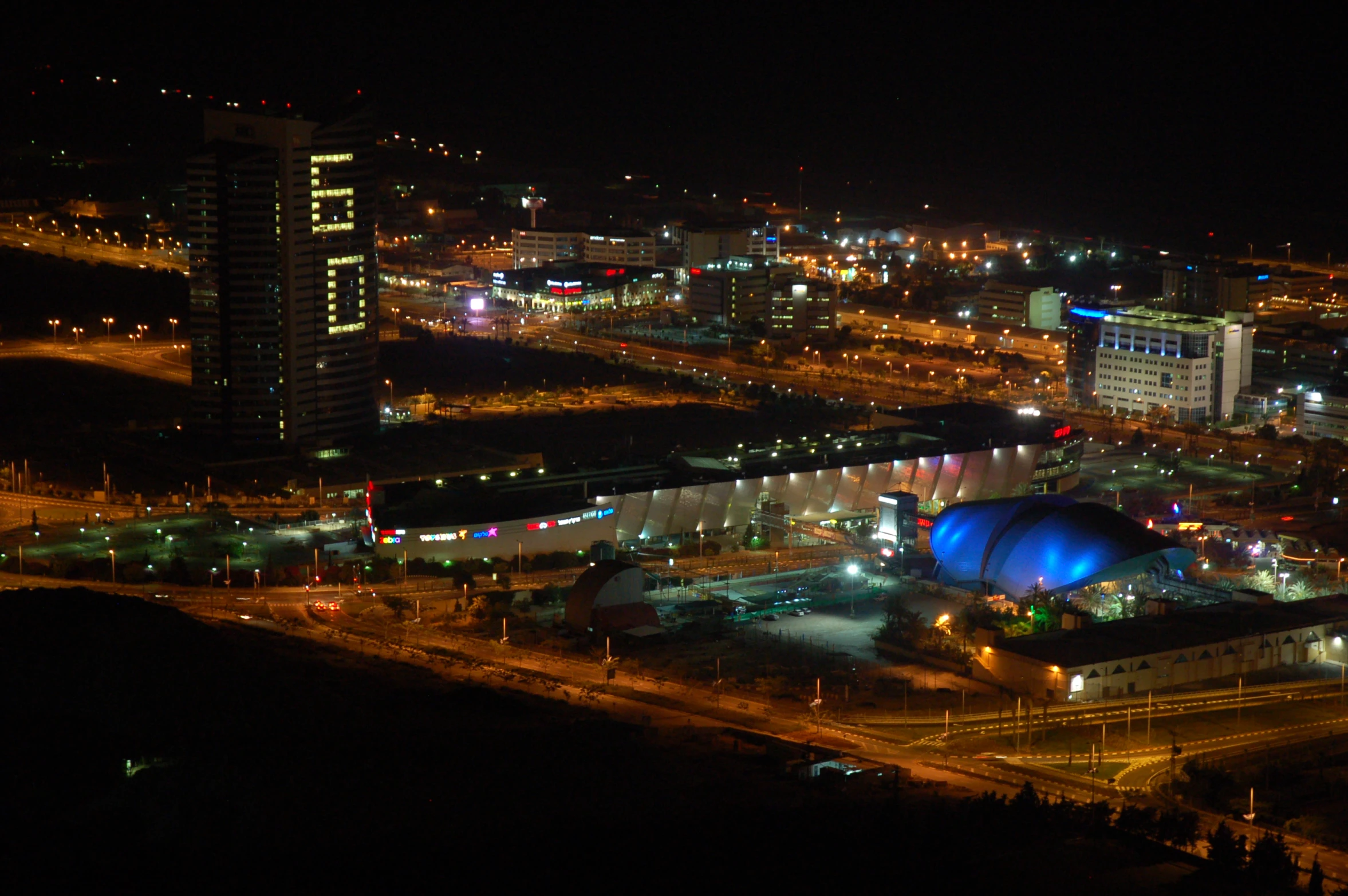 an aerial view of city at night with the lights turned on