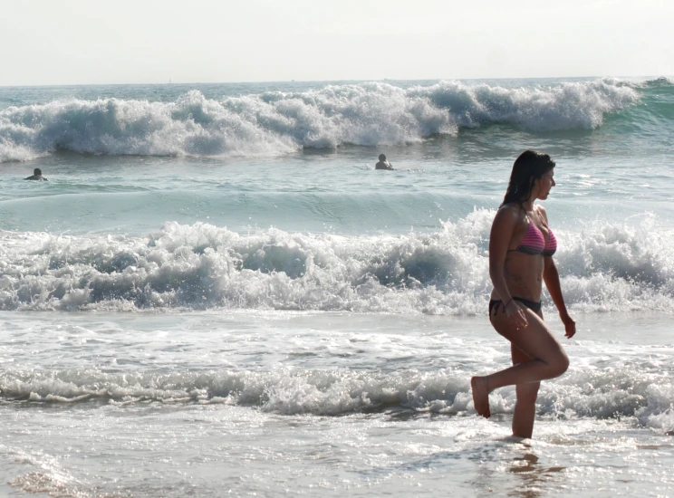 a young woman is running out into the water