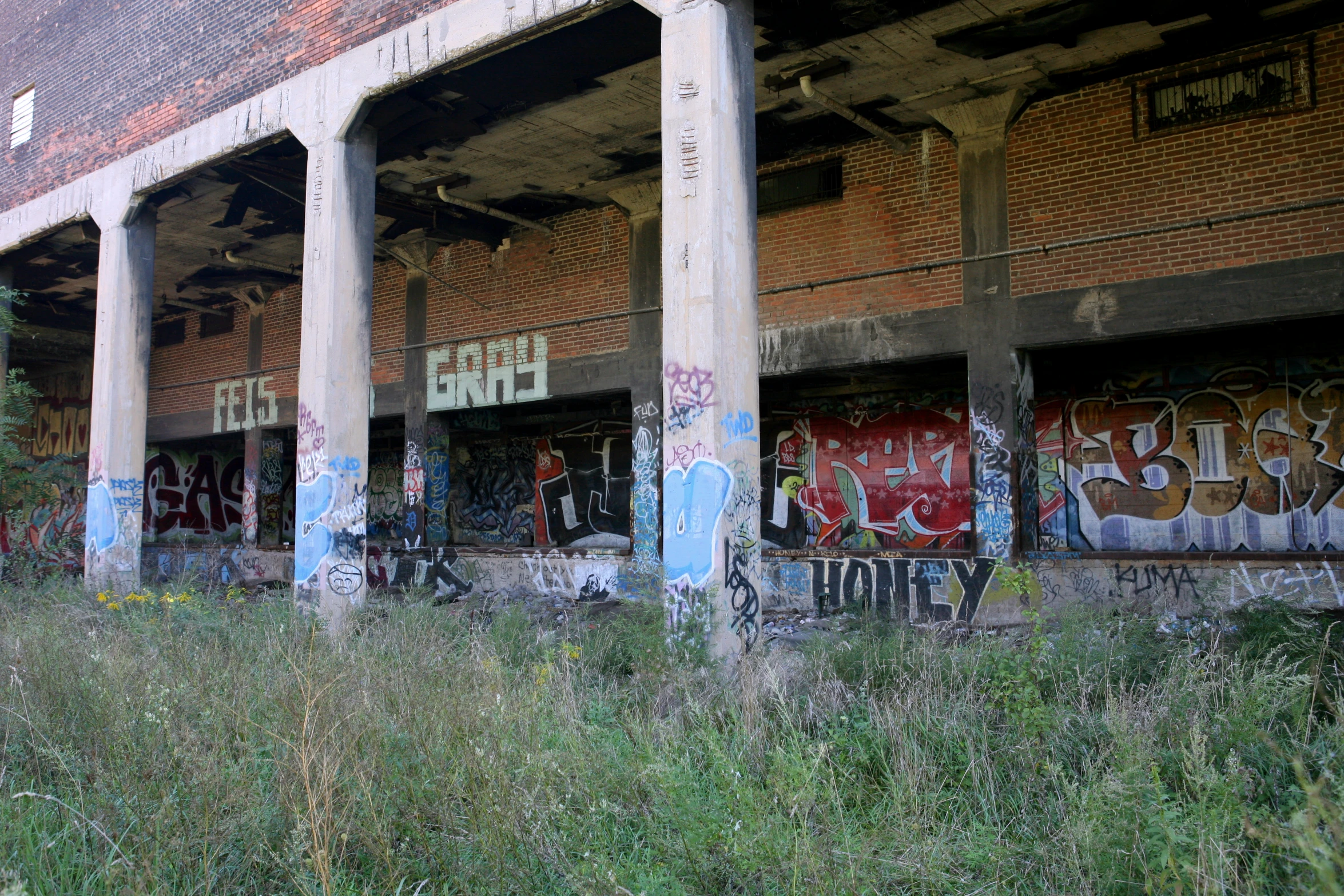 a train covered in graffiti and grafitti next to a wall