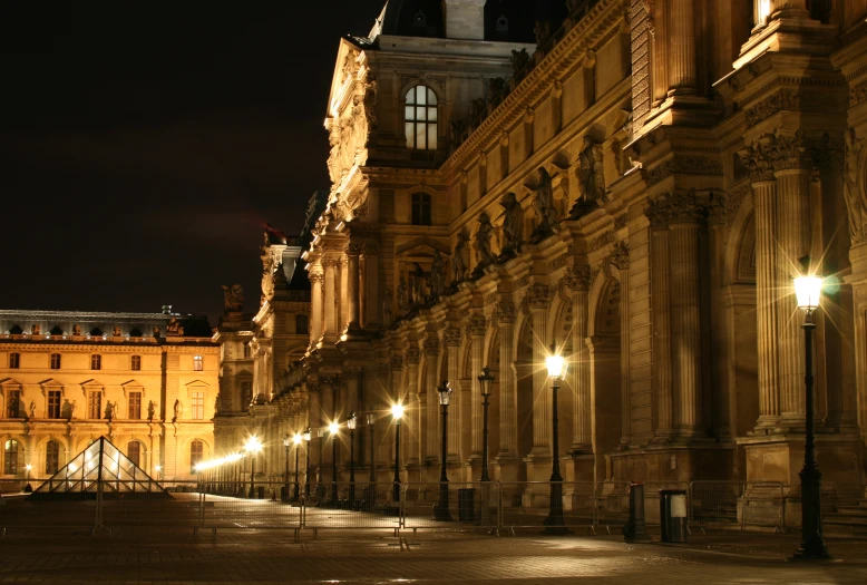 a city street with a clock tower lit up at night