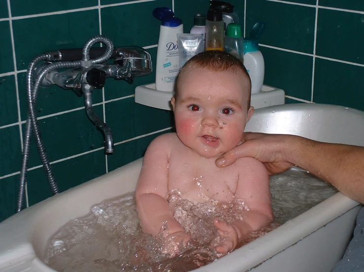 there is a baby sitting in the bathtub