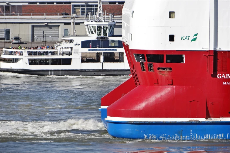 a red and white boat floating along a river