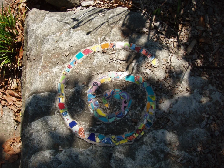 a stone is covered in lots of colorful glass tiles