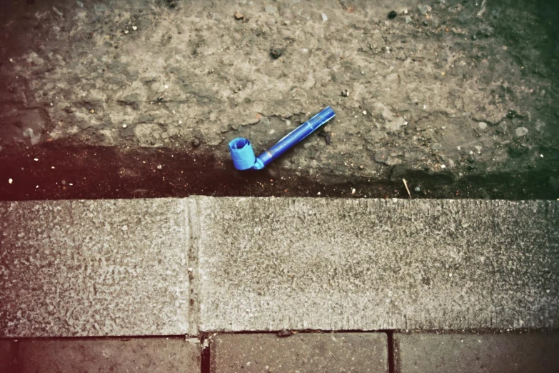 there is a blue tooth brush lying on the ground