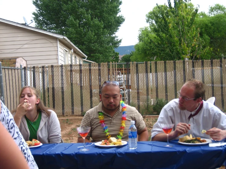 four people sitting around the table enjoying some food