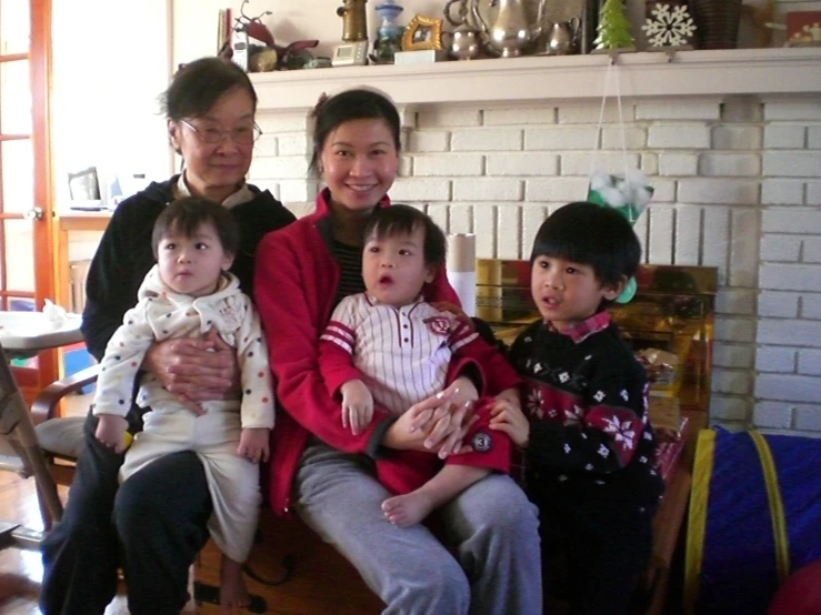 group of adults sitting on wooden chair with two children