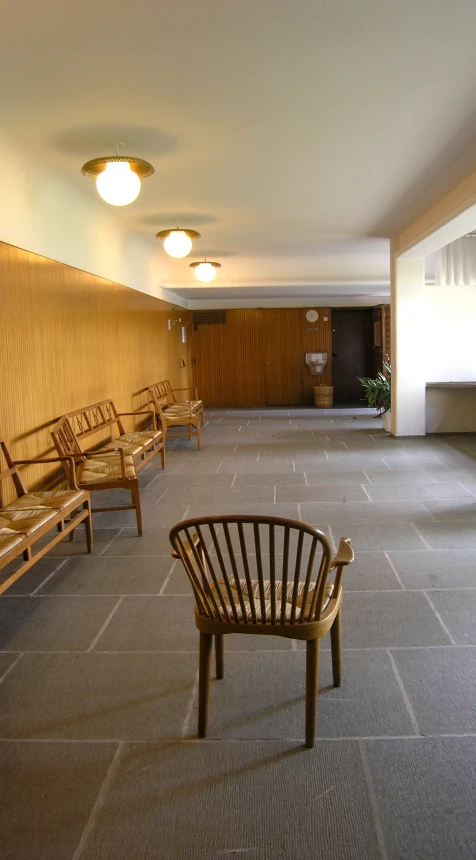 a waiting area with chairs and plants in the center