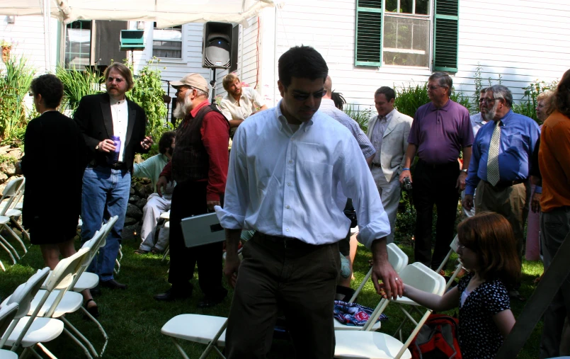 a man in a white shirt and some white folding chairs