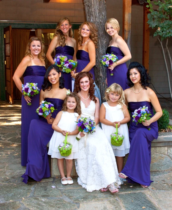 a couple of bridesmaids posing with each other for a group picture