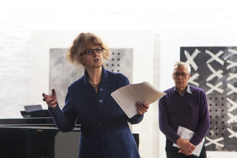 two people standing next to each other with a paper