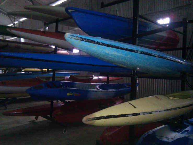 various kayaks are lined up together in a garage