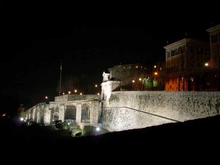 a wall and a tower at night lit up by streetlights