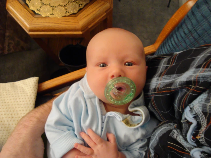 a baby is holding a dummy in the mouth