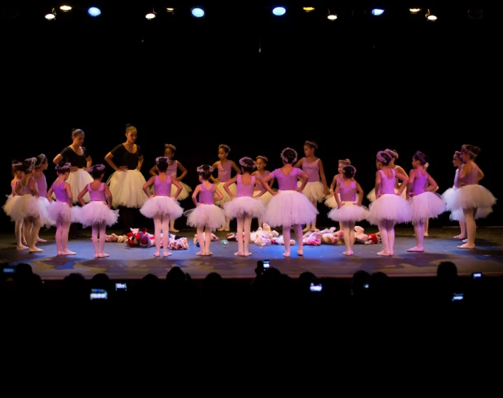 dancers performing on stage in pink outfits